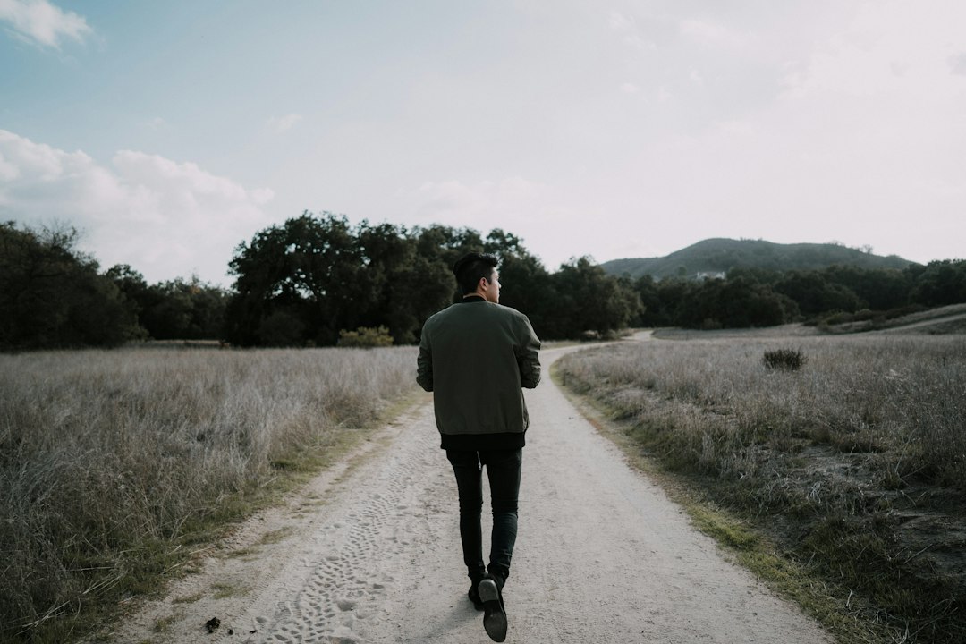 Adult walking along a quiet outdoor path, illustrating paternal health