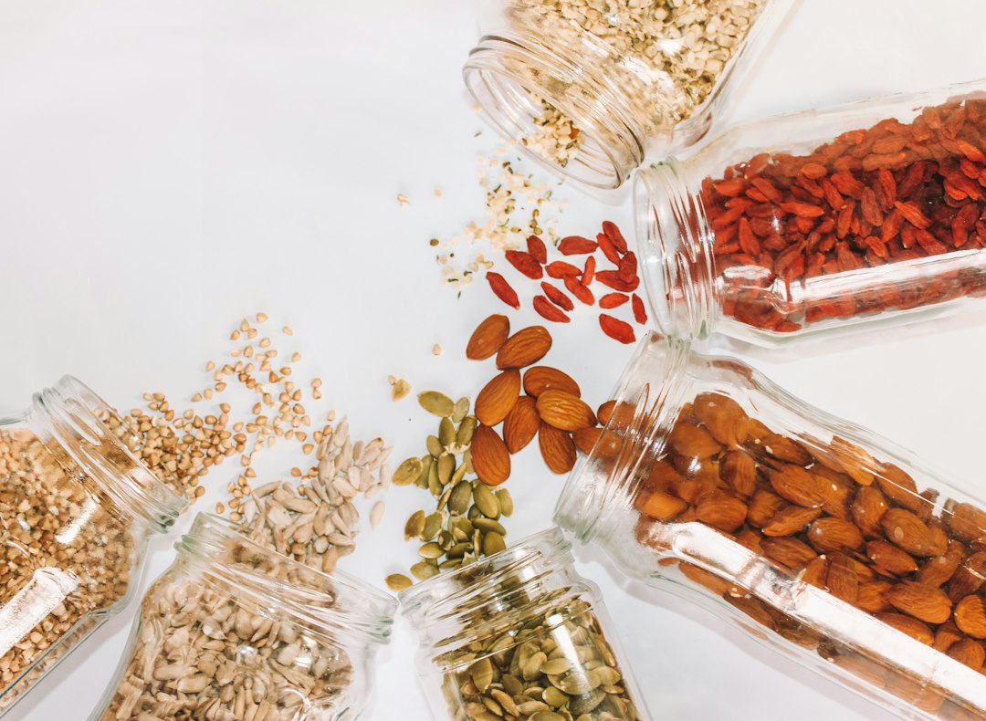 Glass pantry jars filled with nuts, seeds, and whole grains