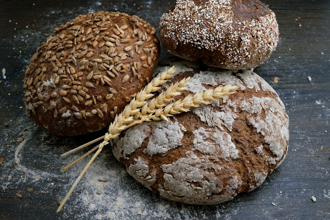 Assorted whole-grain bread loaves on a bakery counter